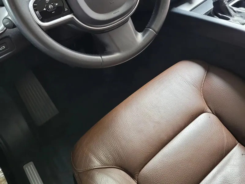 Banco de couro marrom e volante de um Volvo após a higienização