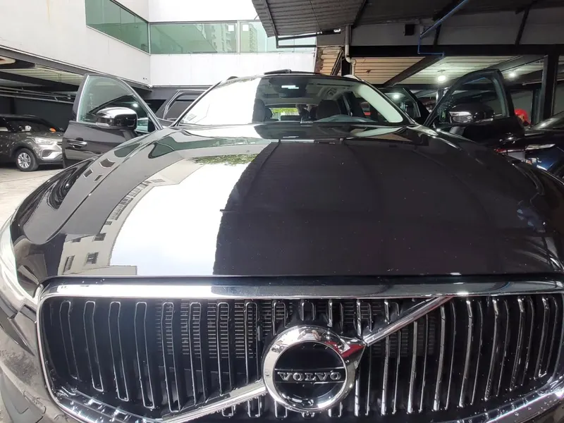 Grade e capô de um Volvo preto brilhando após a lavagem